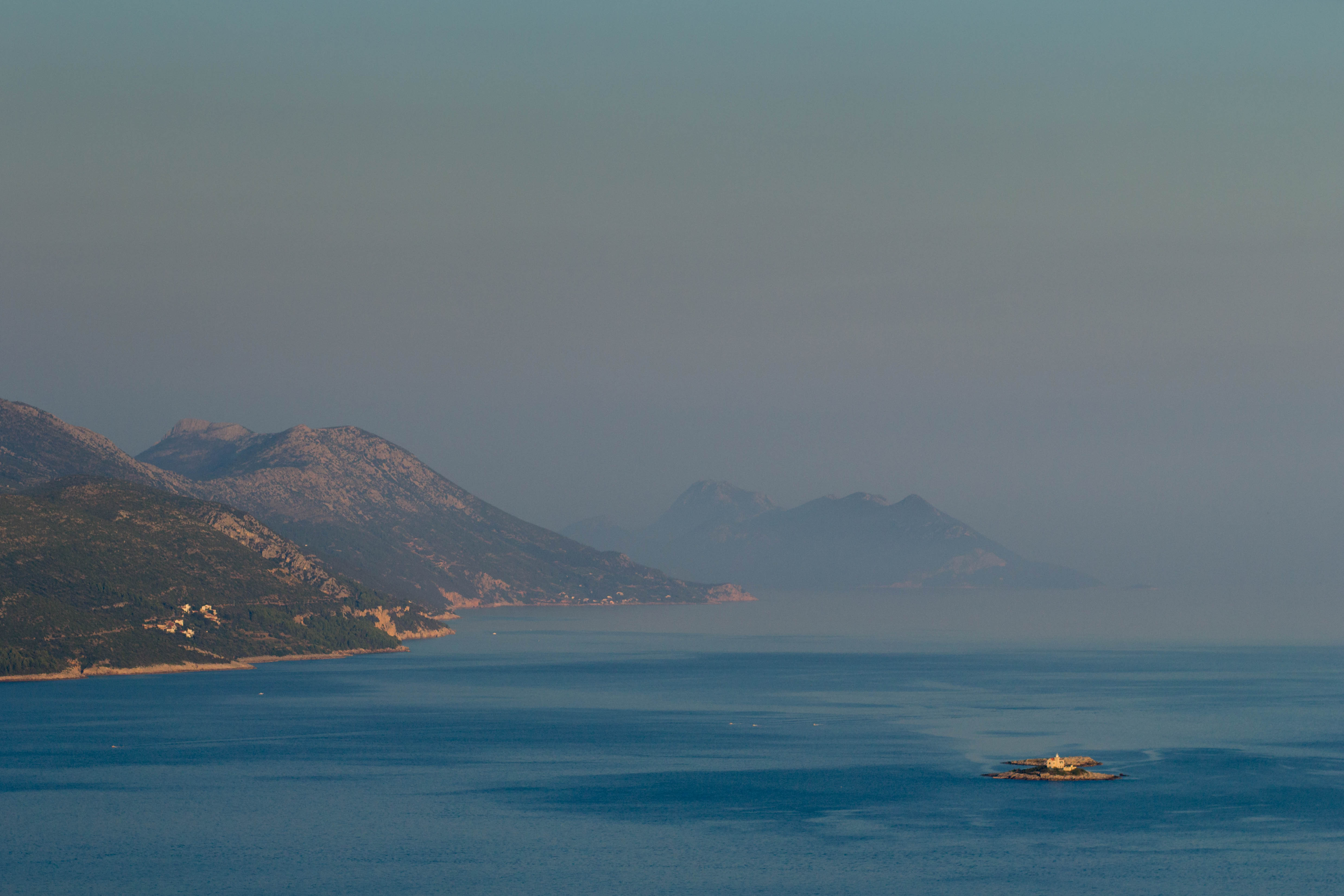 Patrząc dalej na lewo (na wschód) widzimy kolejne dwie wysepki: Vela (z kapliczką) i Mala Sestrica. Za nimi, zachodzące słońce omiata wioski zatunelowego Pelješca oraz Zaljev Žuljana. / 08.jpg 08.jpg